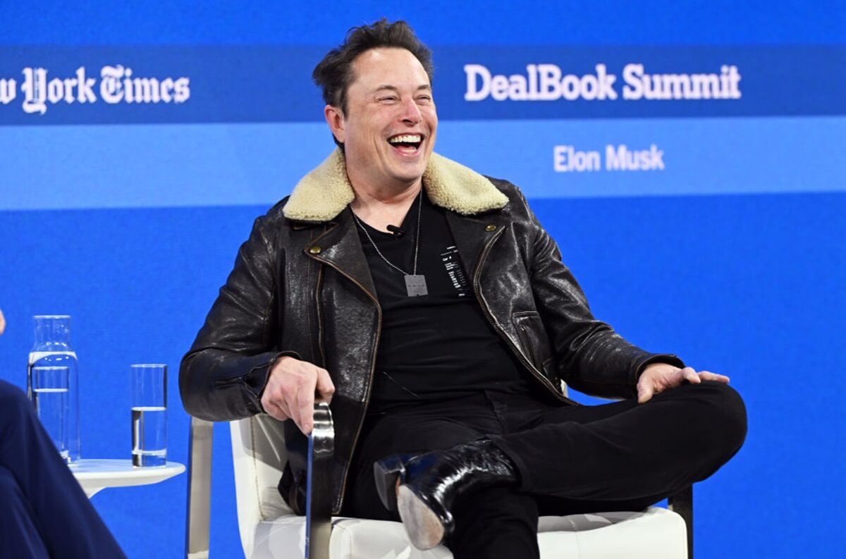 Elon Musk, head of Tesla, smiles at a event.