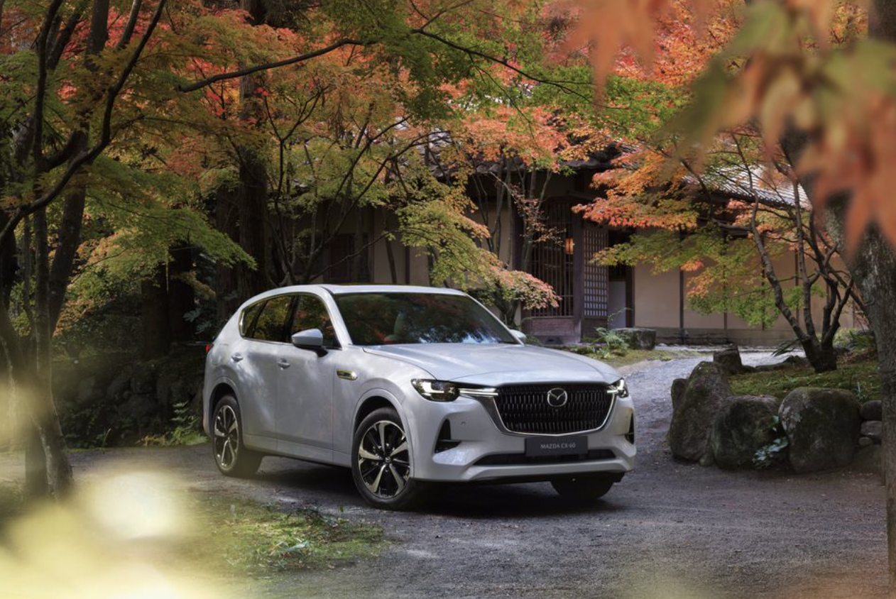 The Mazda CX-60 parked near foliage