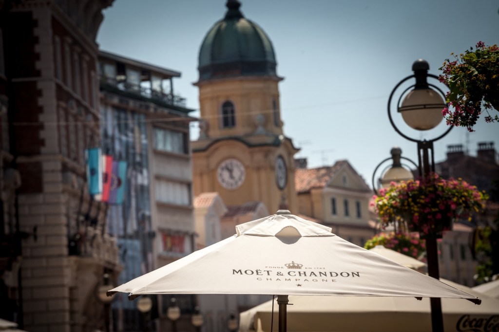 The Moët & Chandon logo on the umbrella outside a European cafe.