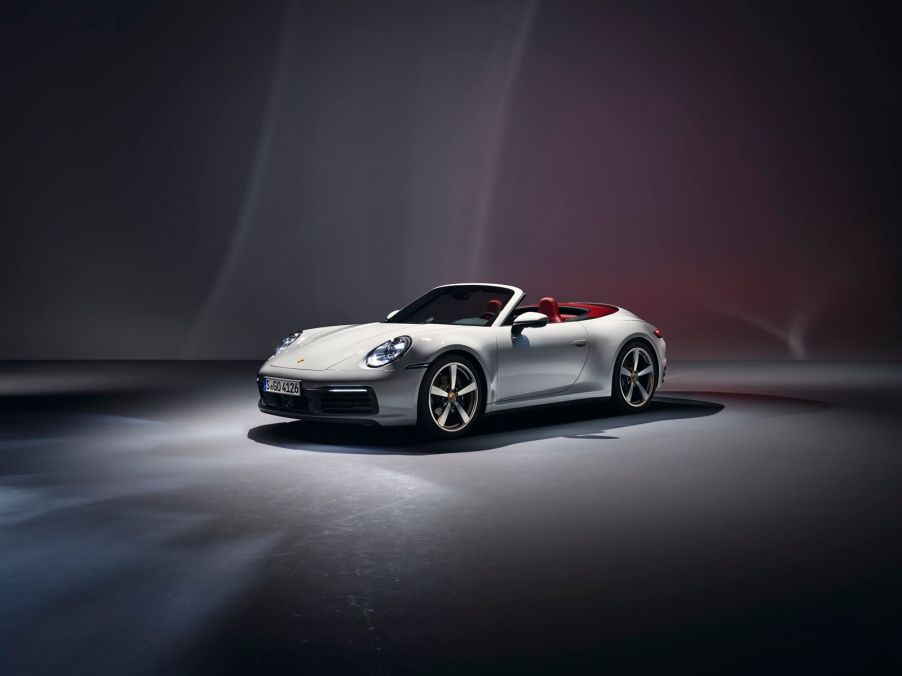A Porsche 911 Cabriolet, the model with the worst depreciation, shows off its convertible top in a studio.