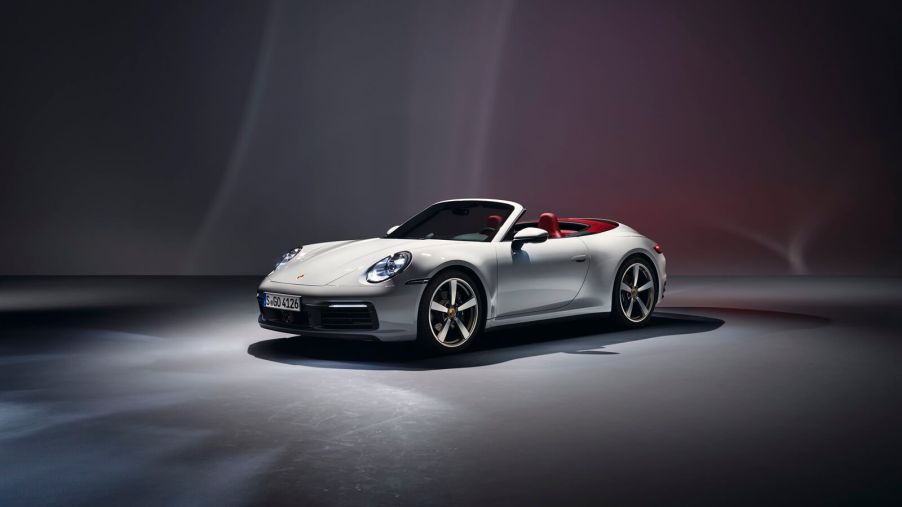 A Porsche 911 Cabriolet, the model with the worst depreciation, shows off its convertible top in a studio.