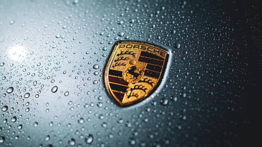 The Porsche crest logo on the hood of a gray car.