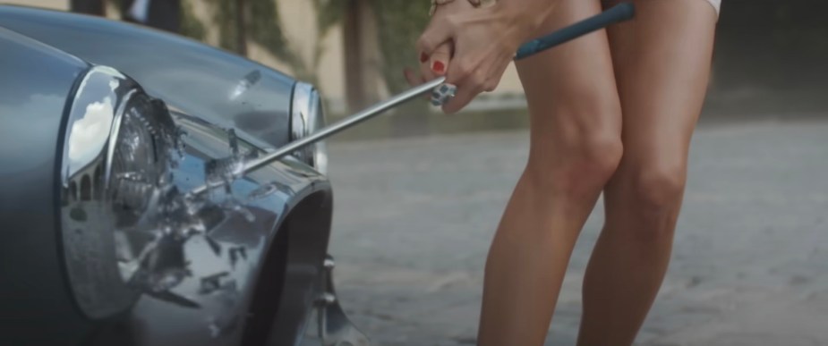 Taylor Swift smashes the headlight of a Shelby Cobra during a music video.
