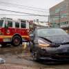 Crashed Tesla vehicle with autopilot with a firetruck visible in the background.