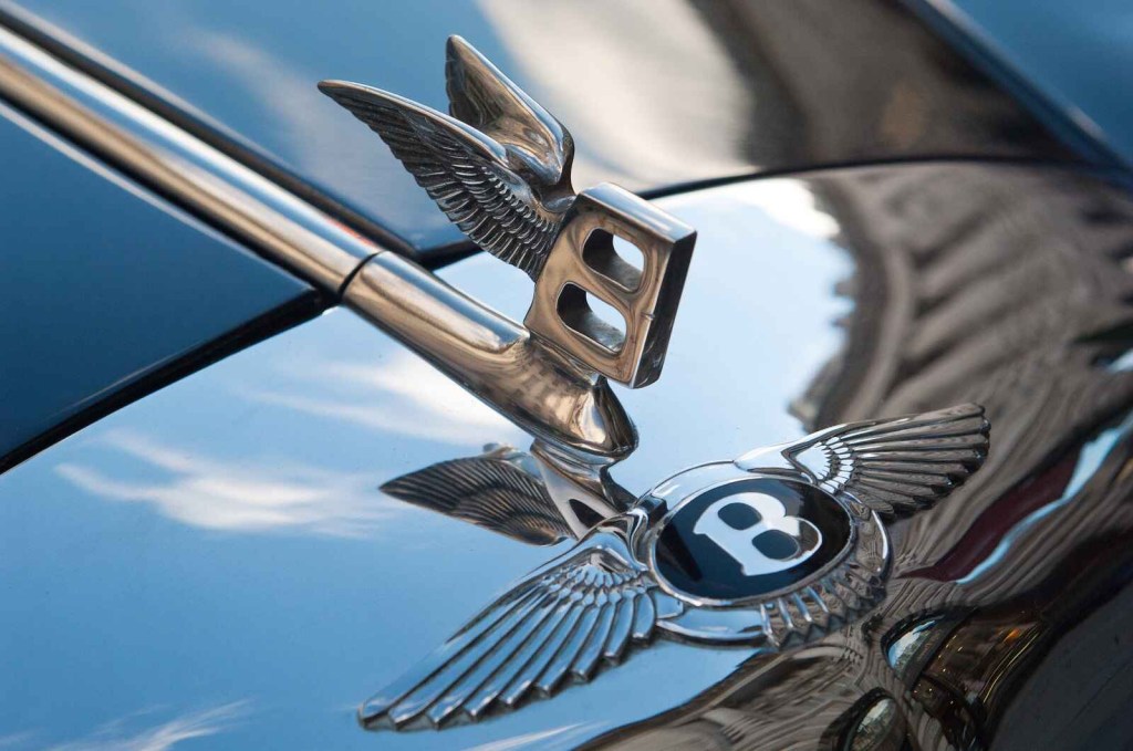 A closeup of a Bentley emblem is shown