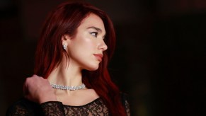 Dua Lipa attends the 3rd Annual Academy Museum Gala at the Academy Museum of Motion Pictures in Los Angeles, December 3, 2023, wearing a diamond necklace, black lace dress, and long red hair.