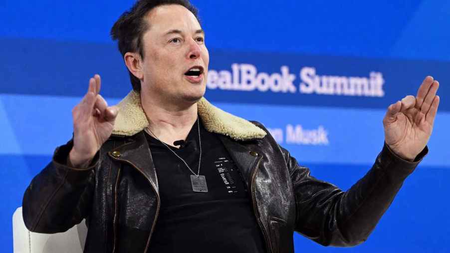Elon Musk gestures with both hands while speaking at the 2023 New York Times DealBook Summit
