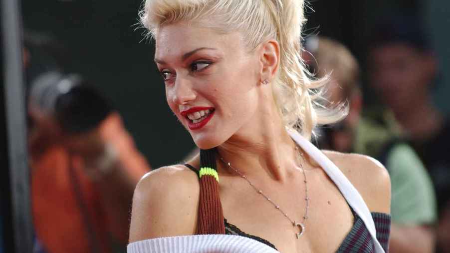 Gwen Stefani is shown at a 2004 movie premier wearing a layered tank top and ponytail