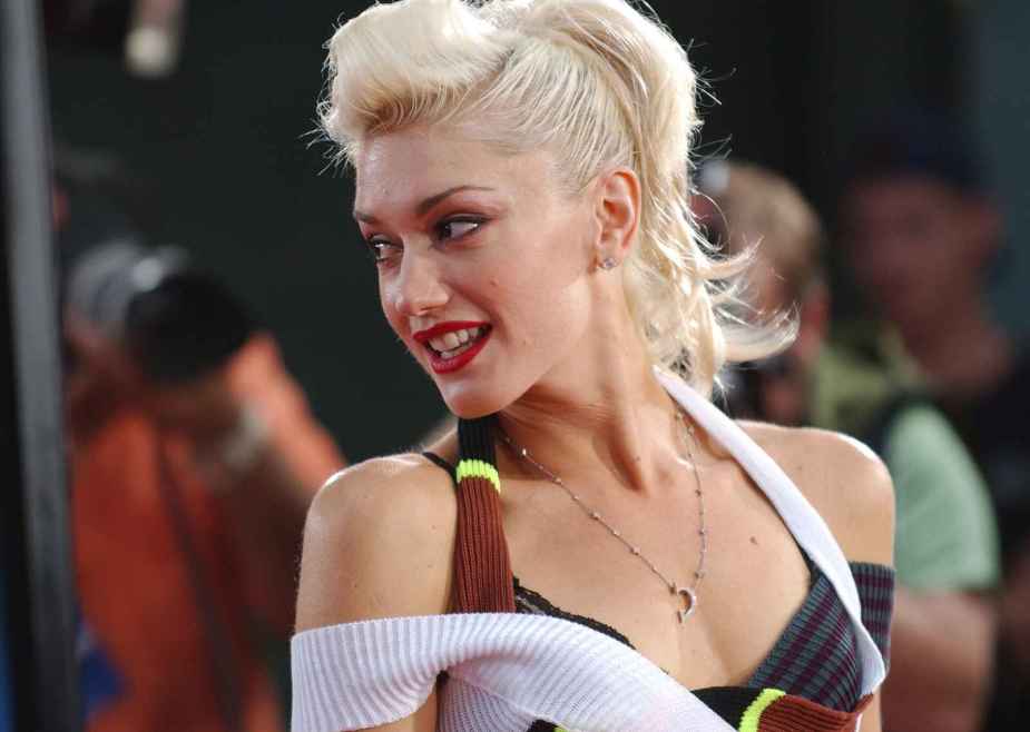 Gwen Stefani is shown at a 2004 movie premier wearing a layered tank top and ponytail