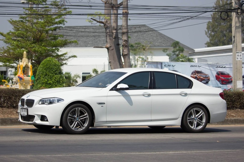 An F10 BMW 5 Series, named in the latest recalls, cruises on city streets.