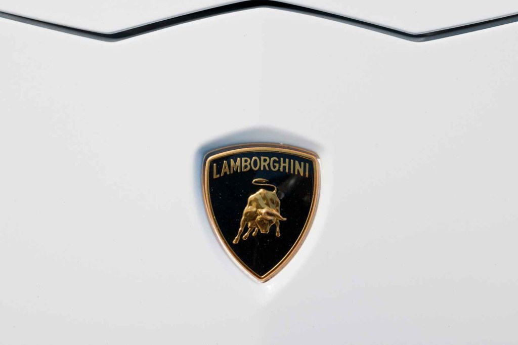 A Lamborghini emblem is shown on a white car