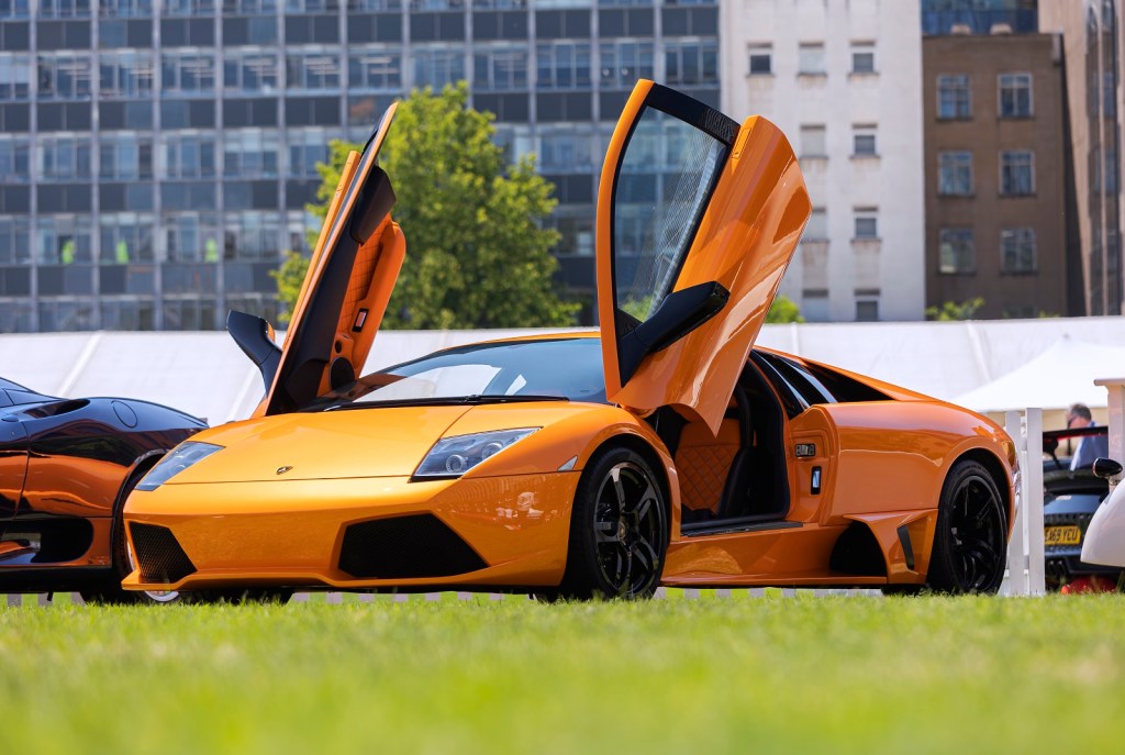 An orange Lamborghini Murcielago is parked with its doors open in left front view
