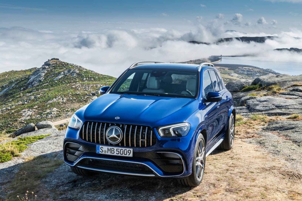 A Mercedes-Benz GLE luxury SUV parked at left front angle on a rocky road with mountains in the background