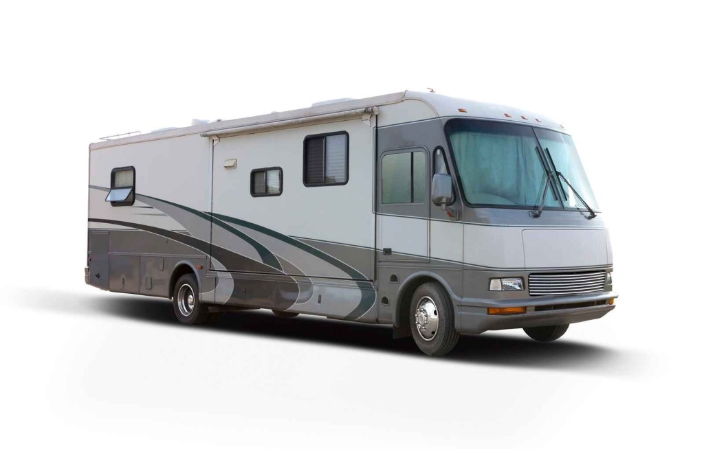 Grey and white RV parked in right front side angle view facing right frame