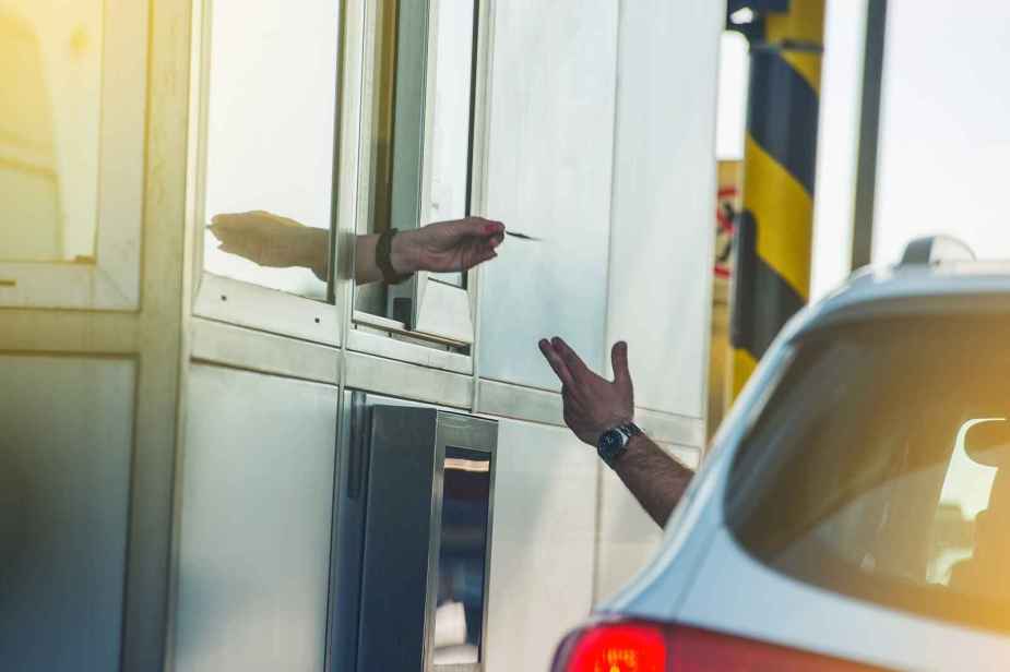 A driver being handed a toll booth receipt