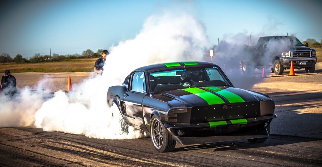 The 1968 Ford Mustang Zombie 222 electromod, an EV restomod, lights up its tires. 