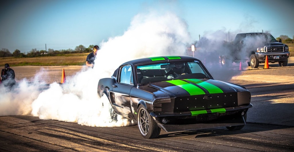The 1968 Ford Mustang Zombie 222 electromod, an EV restomod, lights up its tires.