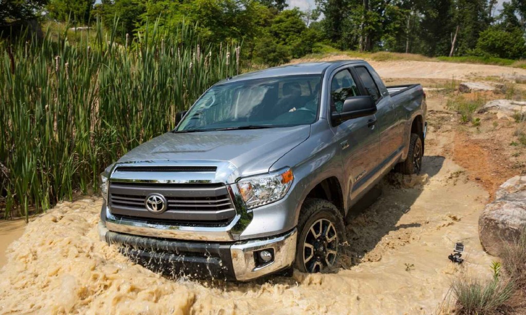 A silver 2016 Toyota Tundra drives down a watery incline