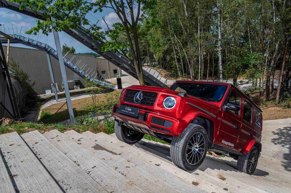 A red Mercedes-Benz G Wagon SUV climbing a set of stairs