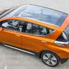 Orange 2023 Chevy Bolt EV electric car with a glass panoramic roof.
