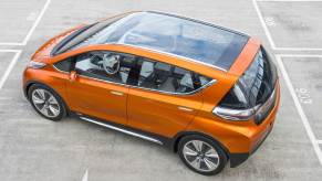 Orange 2023 Chevy Bolt EV electric car with a glass panoramic roof.