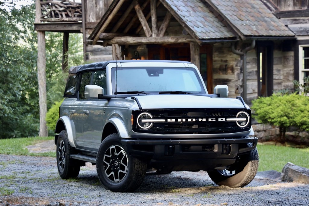 The 2023 Ford Bronco parked near a cabin