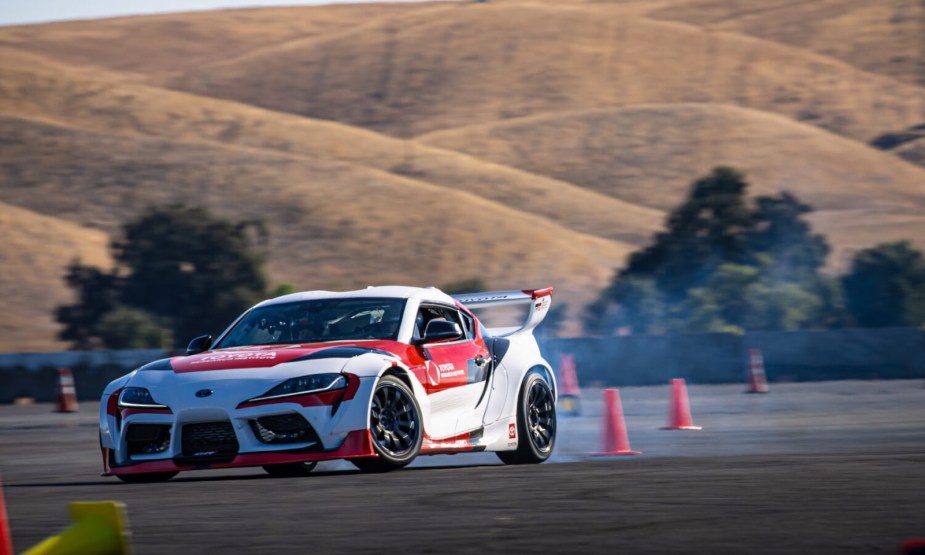 Supra in Toyota racing livery rounds a track.