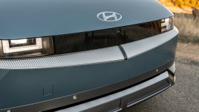 The front emblem of a blue-green 2023 Hyundai Ioniq 5 in close front end view