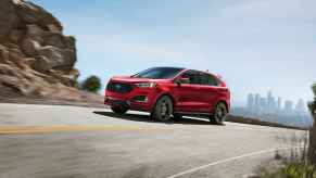 A red 2024 Ford Edge shown driving up a rocky paved road