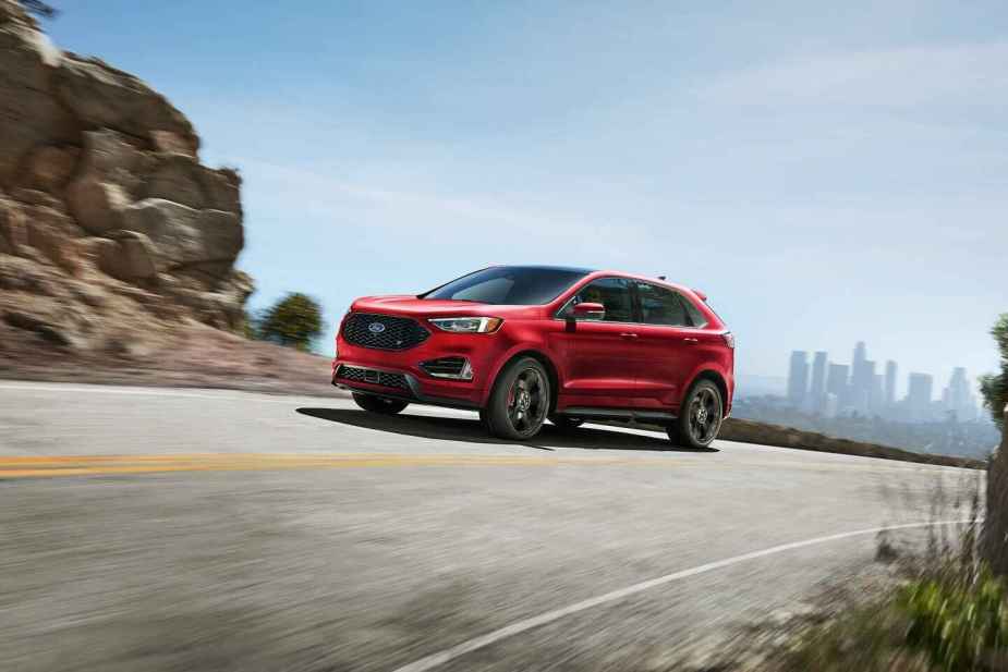 A red 2024 Ford Edge shown driving up a rocky paved road