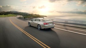 A 2024 Chevrolet Malibu, a model on the list of the most popular used cars, drives on a coastal highway.