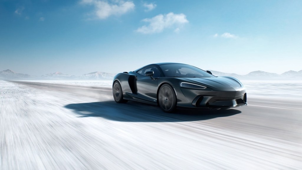 A 2025 McLaren GTS kicks up dust as it speeds on a salt flat.