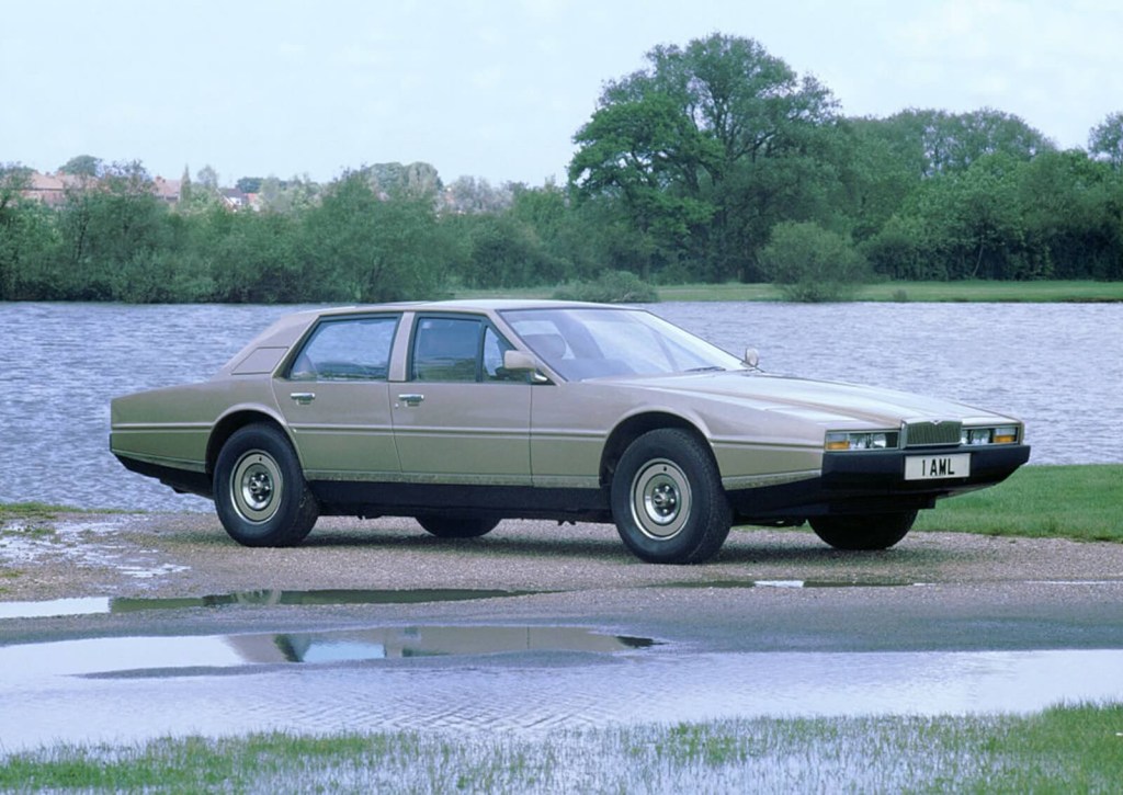 A 1981 Aston Martin Lagonda classic luxury car parks on a wet street. 