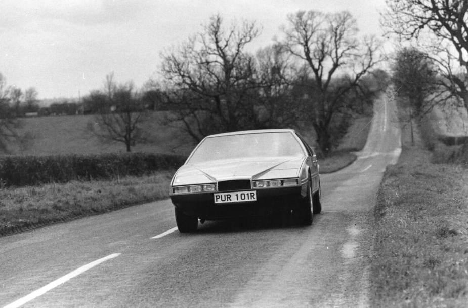 A classic 1976 Aston Martin Lagonda cruises down an English road.