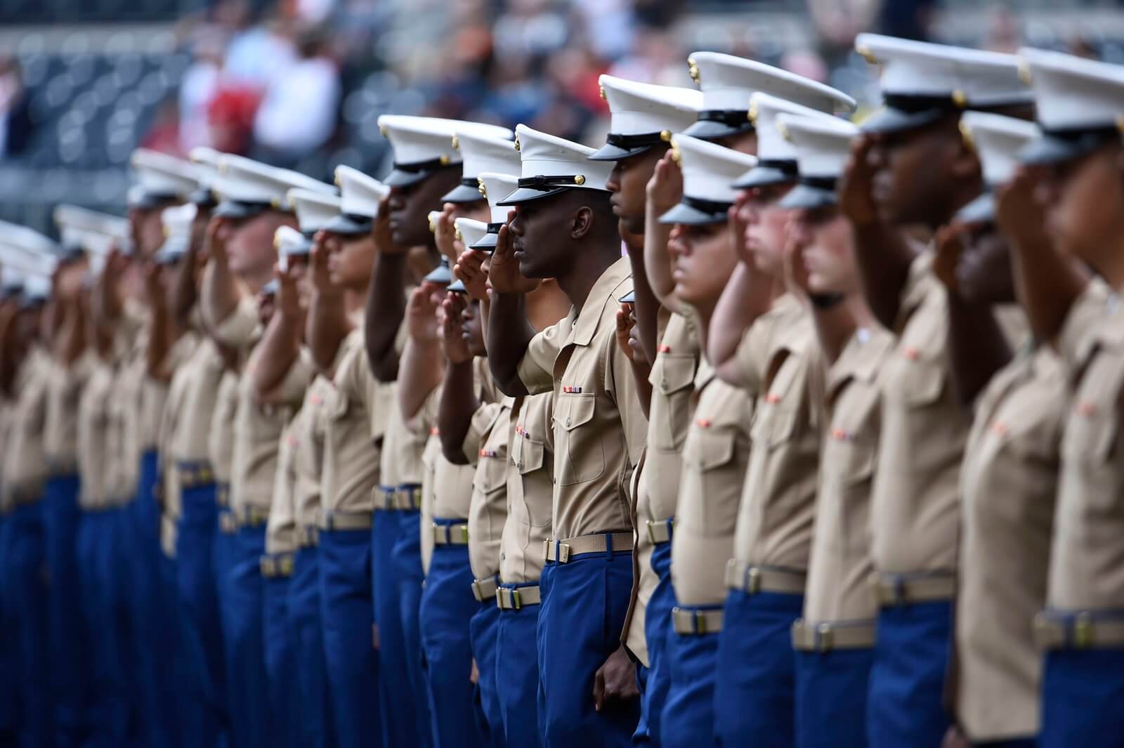 Young marines salute after joining the military and finishing boot camp.