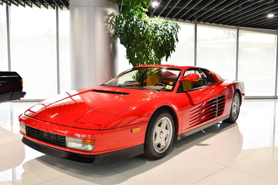 Red Ferrari supercar parked in a museum.