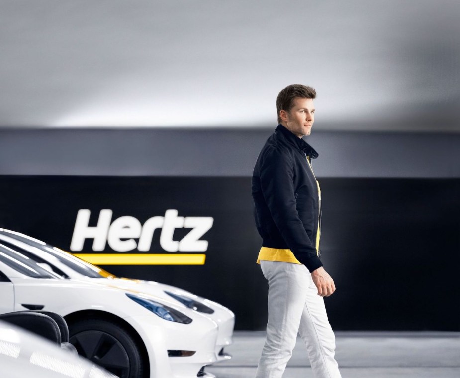 Quarterback Tom Brady walks in front of Hertz's Tesla Model 3 rental fleet.