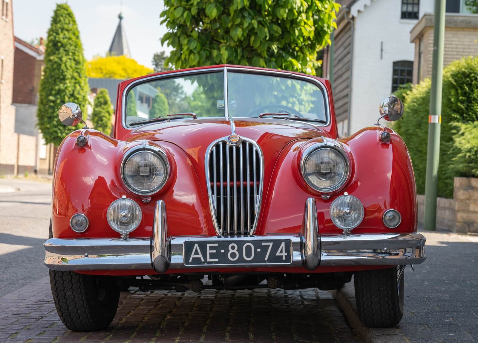 A red Jaguar XK140 shows off its front-end styling. 
