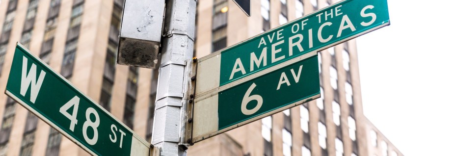 Street signs for the perpendicular 48th street and Avenue of the Americas in Manhattan