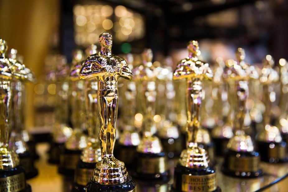 A row of golden academy award "Oscar" trophies