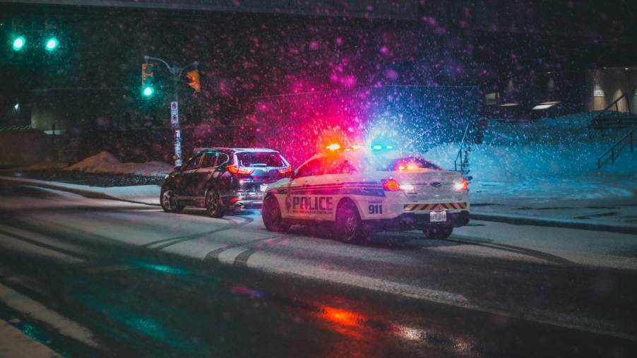 Police cruiser speeding ticket traffic stop in the snow.