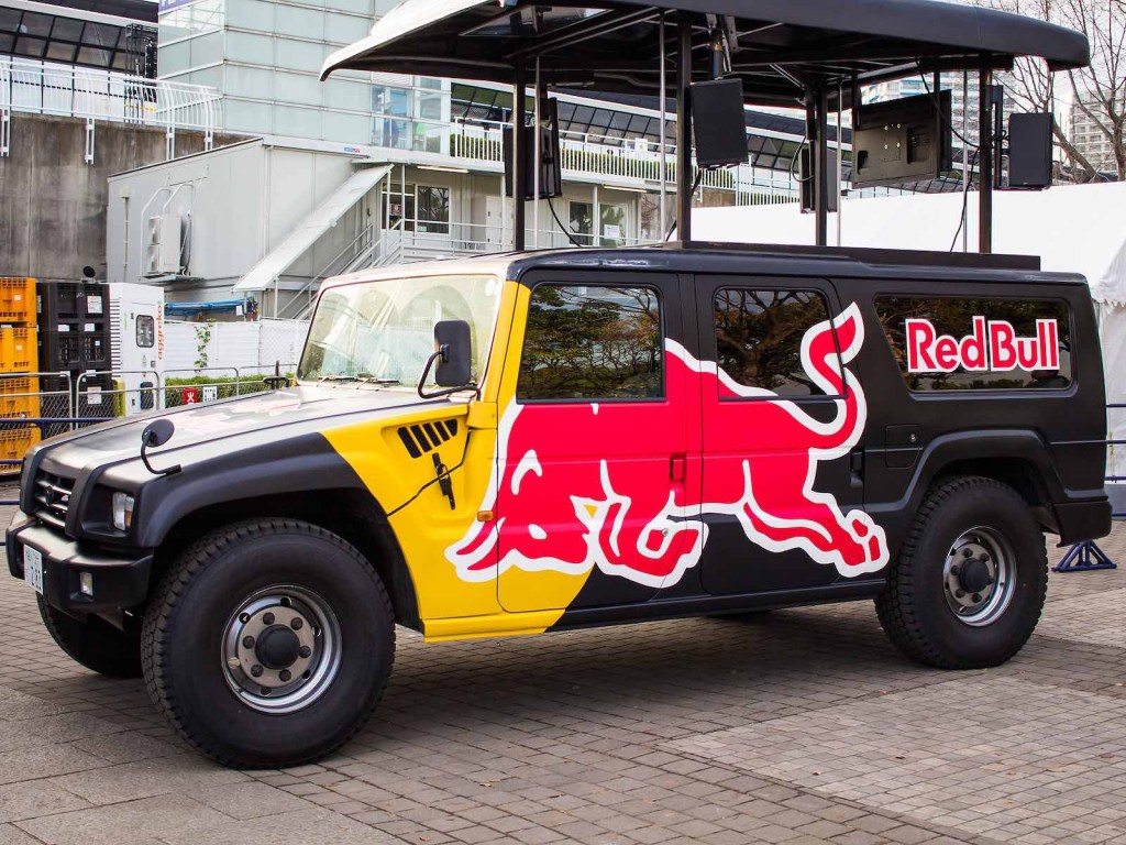 Toyota Mega Cruiser SUV with Red Bull livery parked in front of a building.