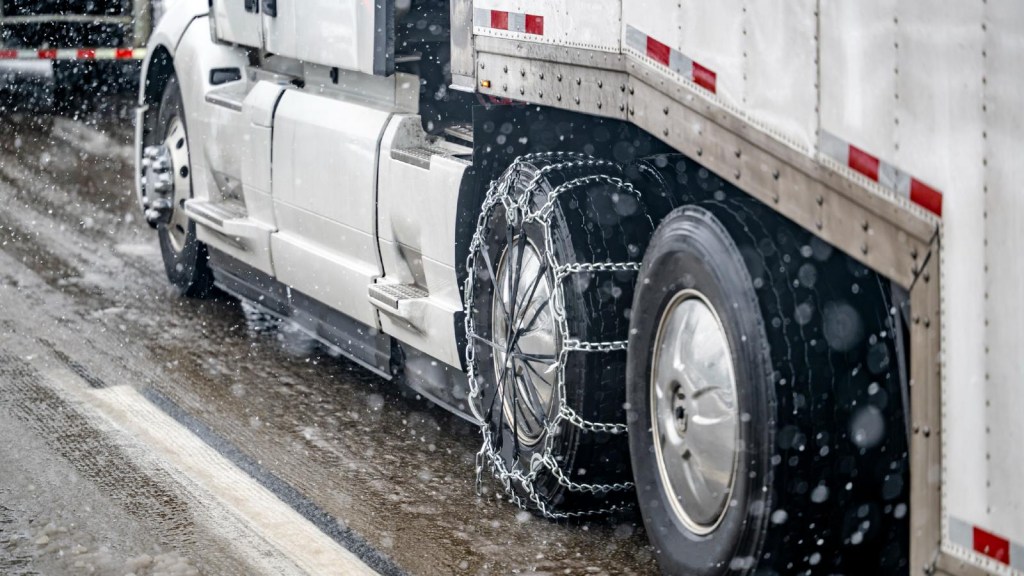 Semi-Truck Using Tire Chains to increase traction while driving on snow-covered roads.