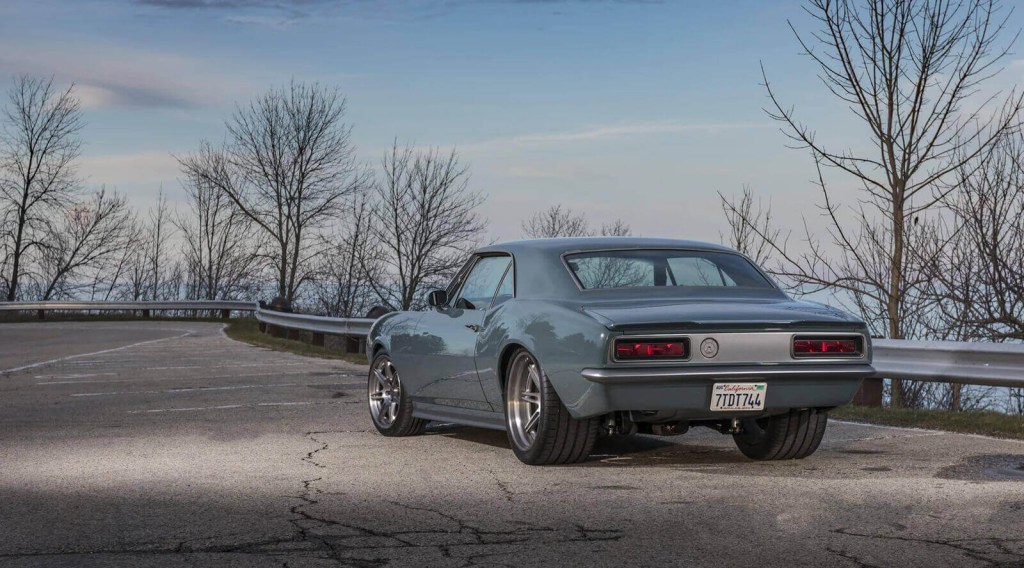 A SpeedKore 1967 Chevrolet Camaro custom build parks on the road.