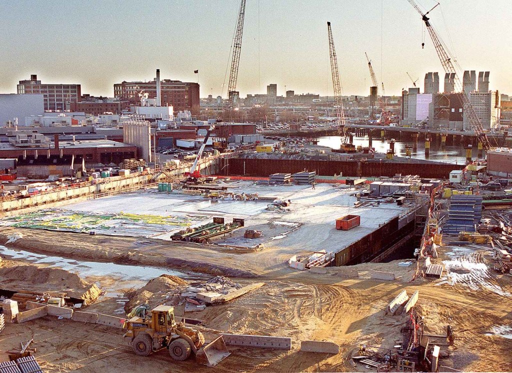 Boston's Big Dig highway project under construction outside with dirt, flattened ground, and cranes in the background