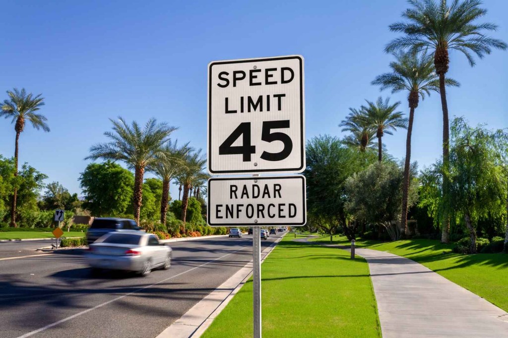 A speed limit 45 sign posted on a California street with palm trees in the background