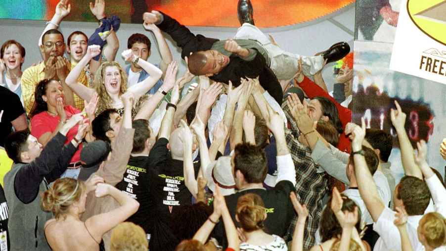 GM brand manager Don Butler crowd surfs during the January 2000 reveal of the Pontiac Aztec at the Detroit Auto Show