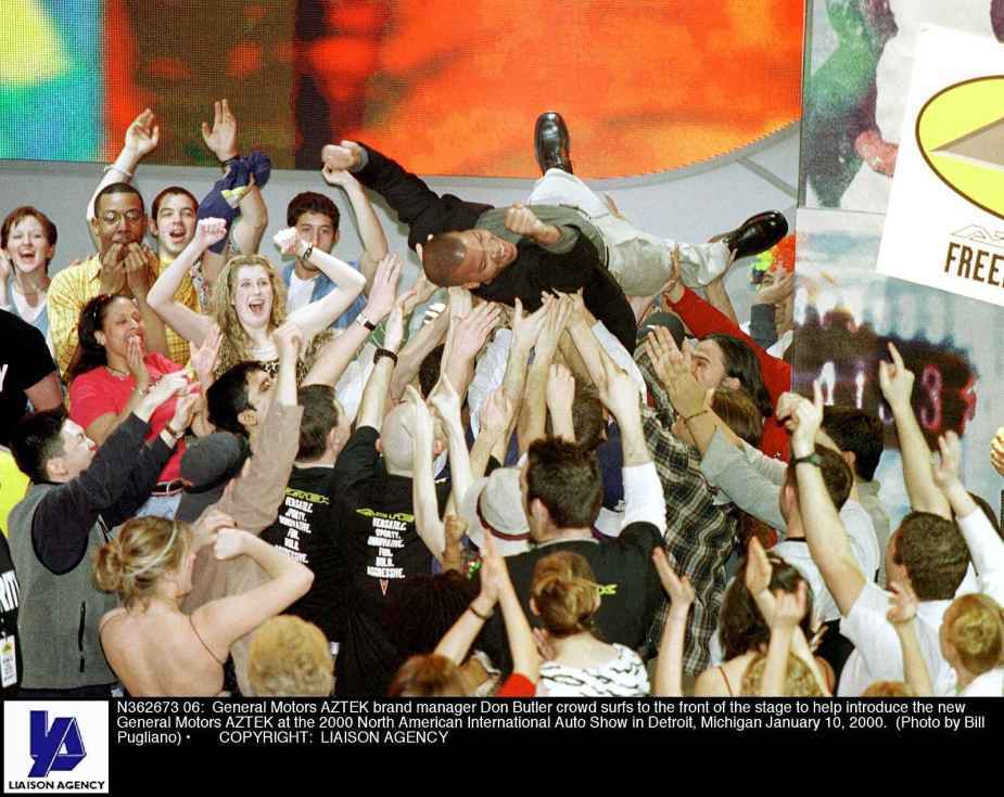 GM brand manager Don Butler crowd surfs during the January 2000 reveal of the Pontiac Aztec at the Detroit Auto Show