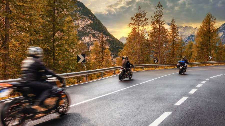 A set of motorcycle riders head into the mountains.