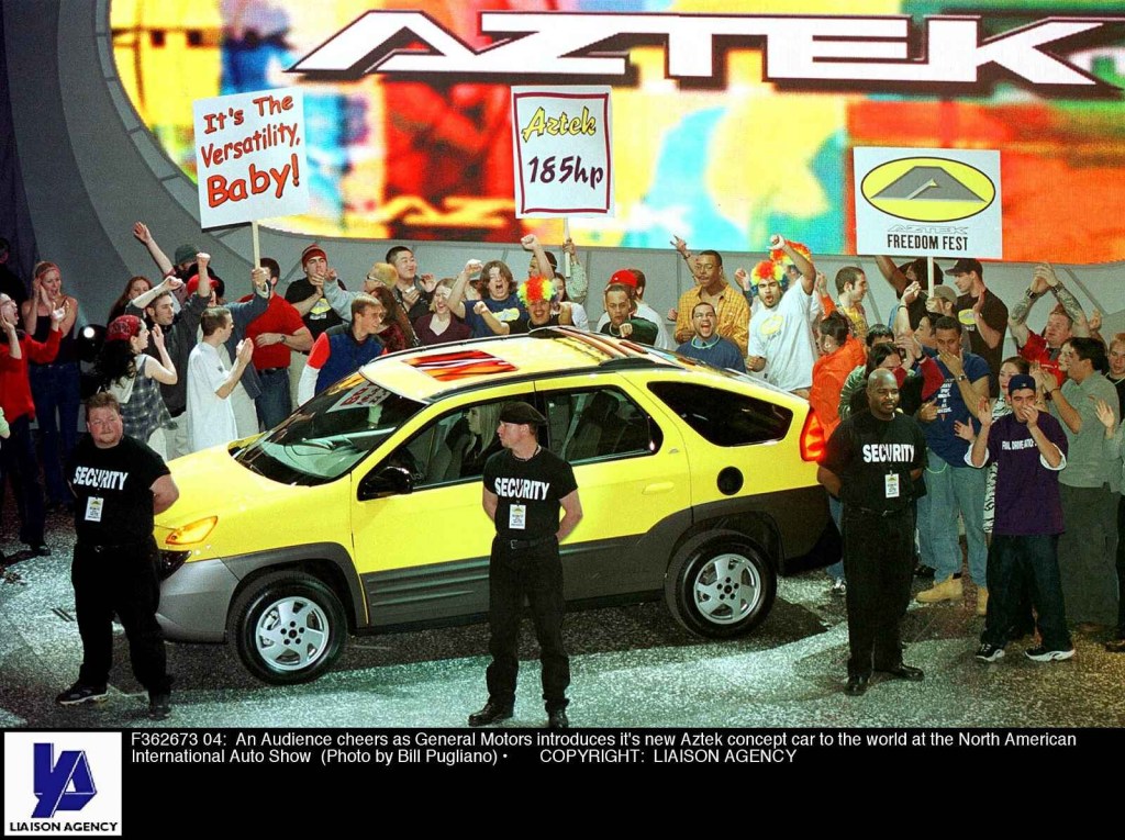 A yellow Pontiac Aztek is shown with fake security guards and a hired crowd at the 2000 Detroit Auto Show